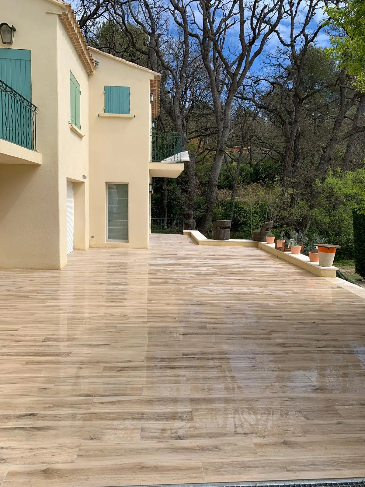 Grande terrasse en lames de bois devant la maison